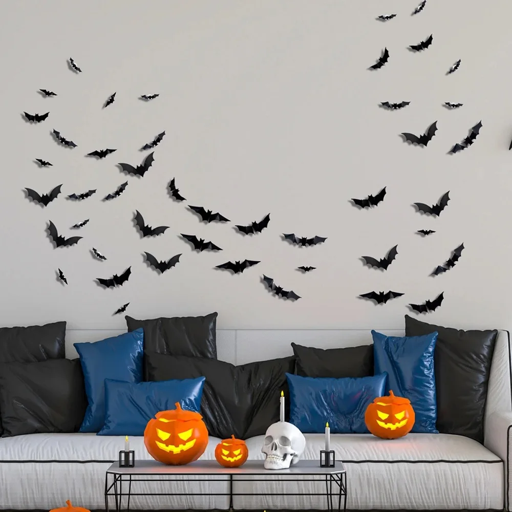 Unlit black bats arranged above a gray sofa with Halloween pumpkins on the coffee table