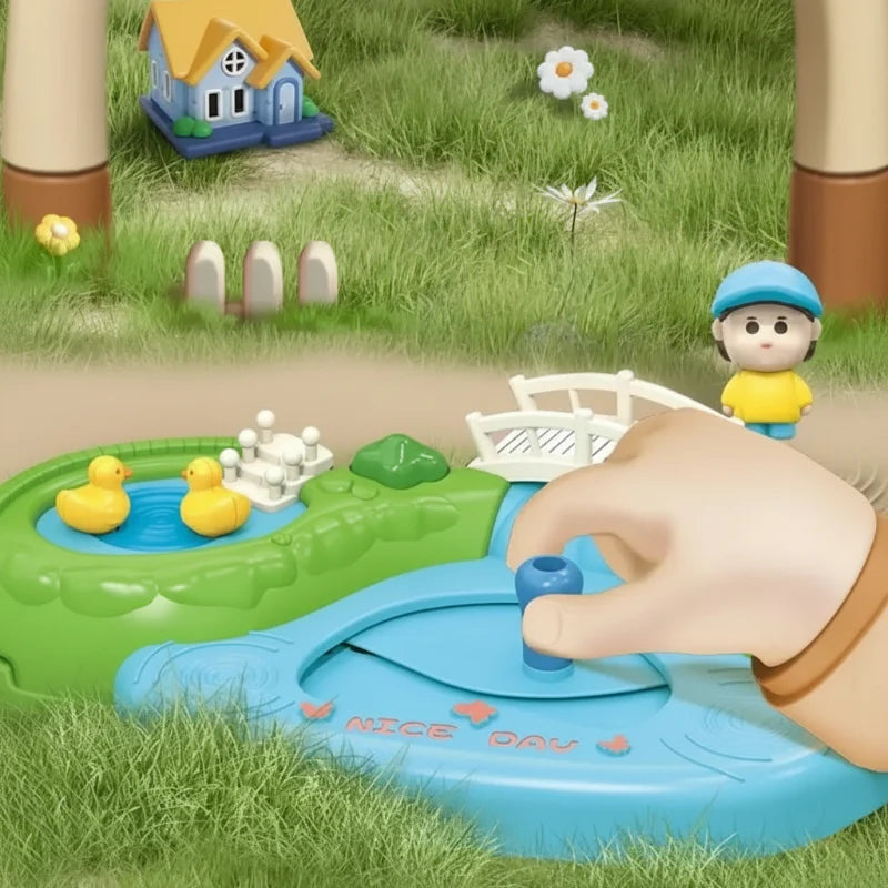 Hand moving the blue control on a magnetic village playset beside a pond and bridge