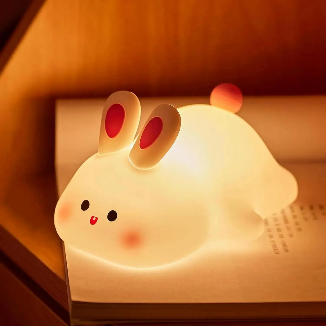 Bunny night light casting a warm glow on an open book