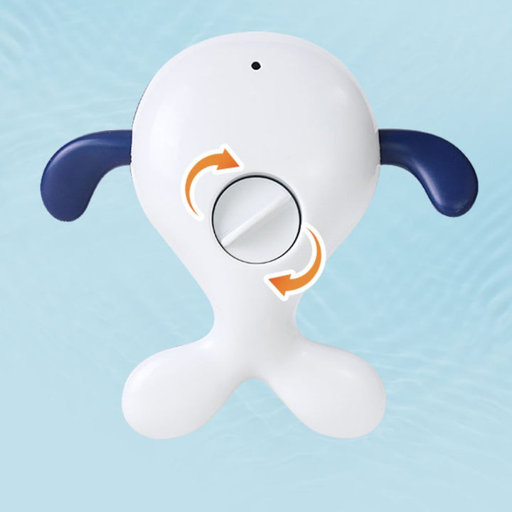 Underside of a whale bath toy showing navy fins, a white tail and a turning dial.