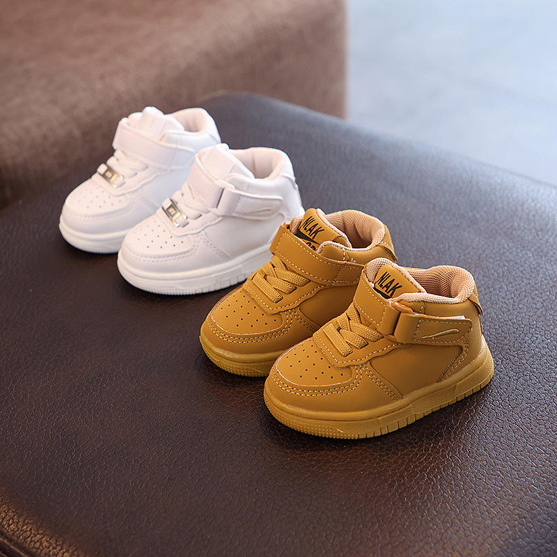 White and khaki high-top sneaker pairs arranged on a dark bench