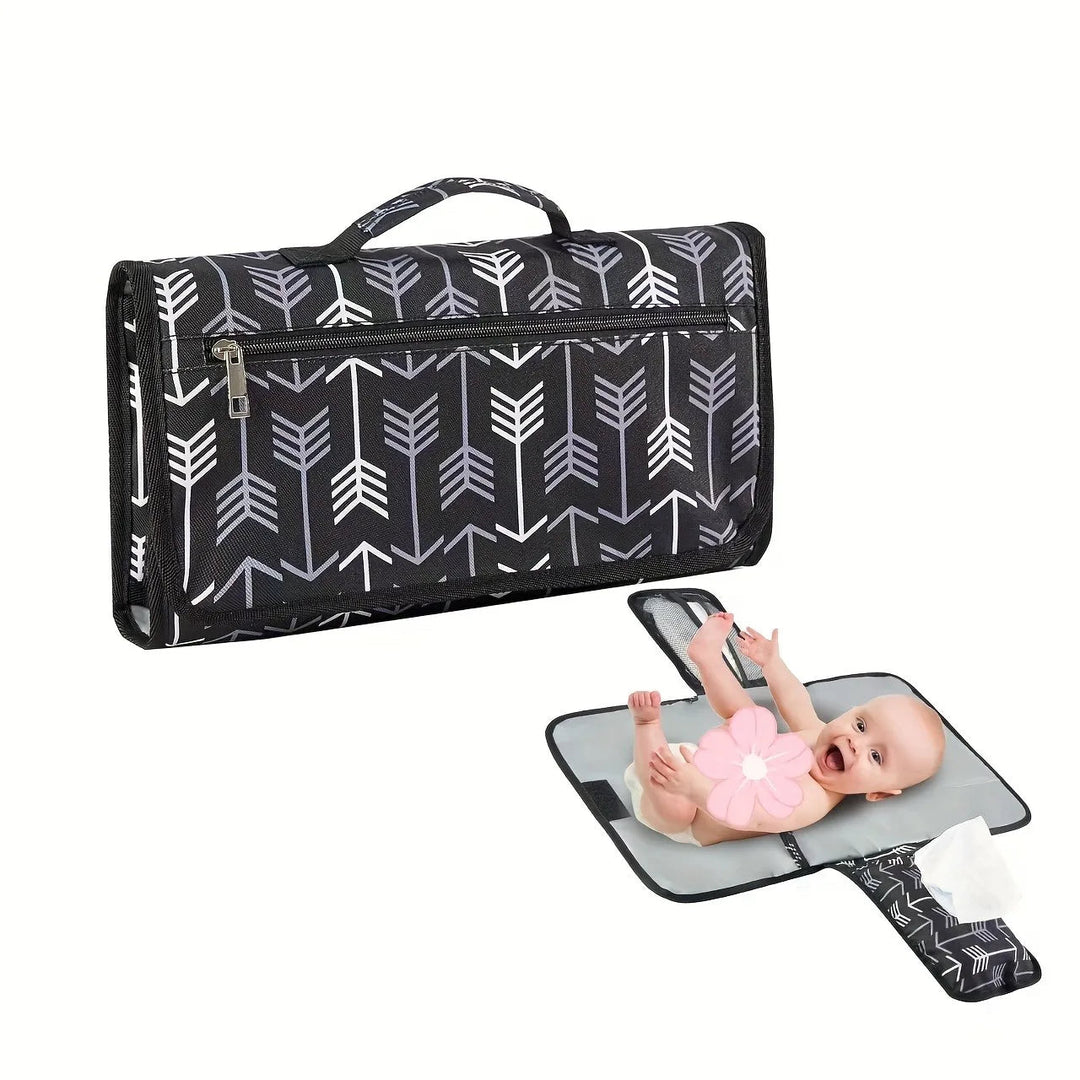 Black changing mat with white arrows, shown folded with a handle and unfolded with a baby.