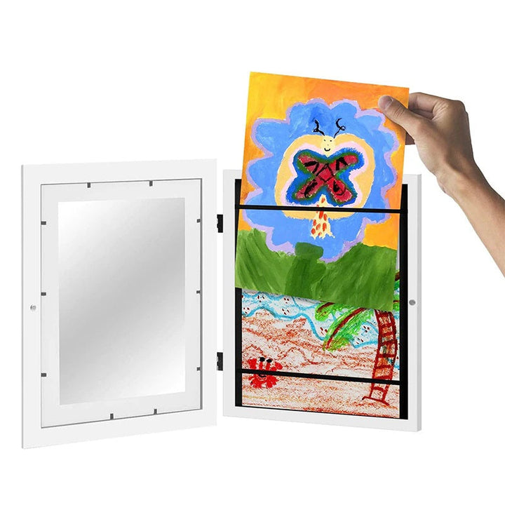 Open white art frame with a colorful drawing being placed above earlier artwork
