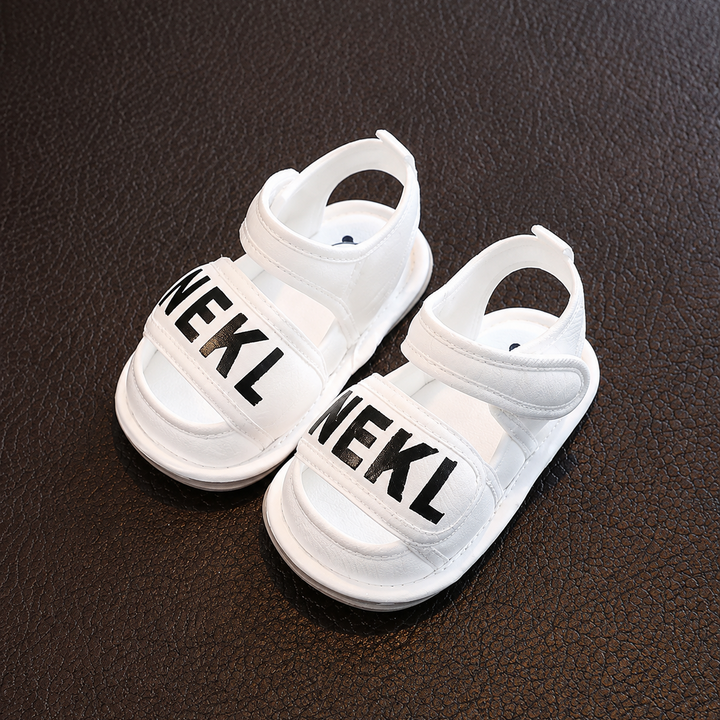 Pair of white baby sandals with wide front straps and adjustable ankle straps