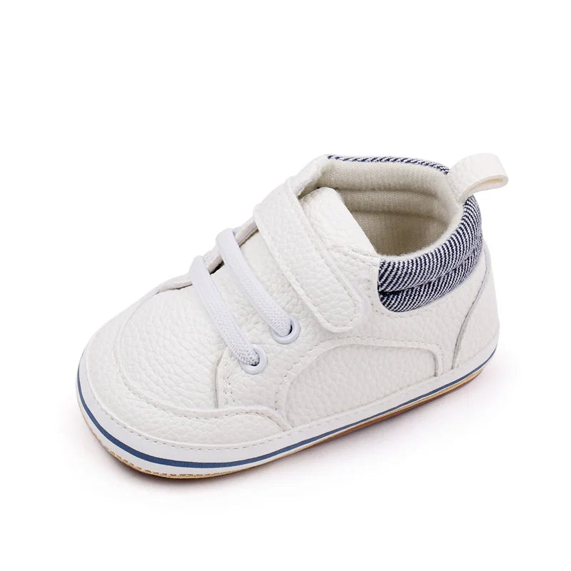 White baby sneaker with a hook-and-loop strap, lace detailing, and a striped heel collar
