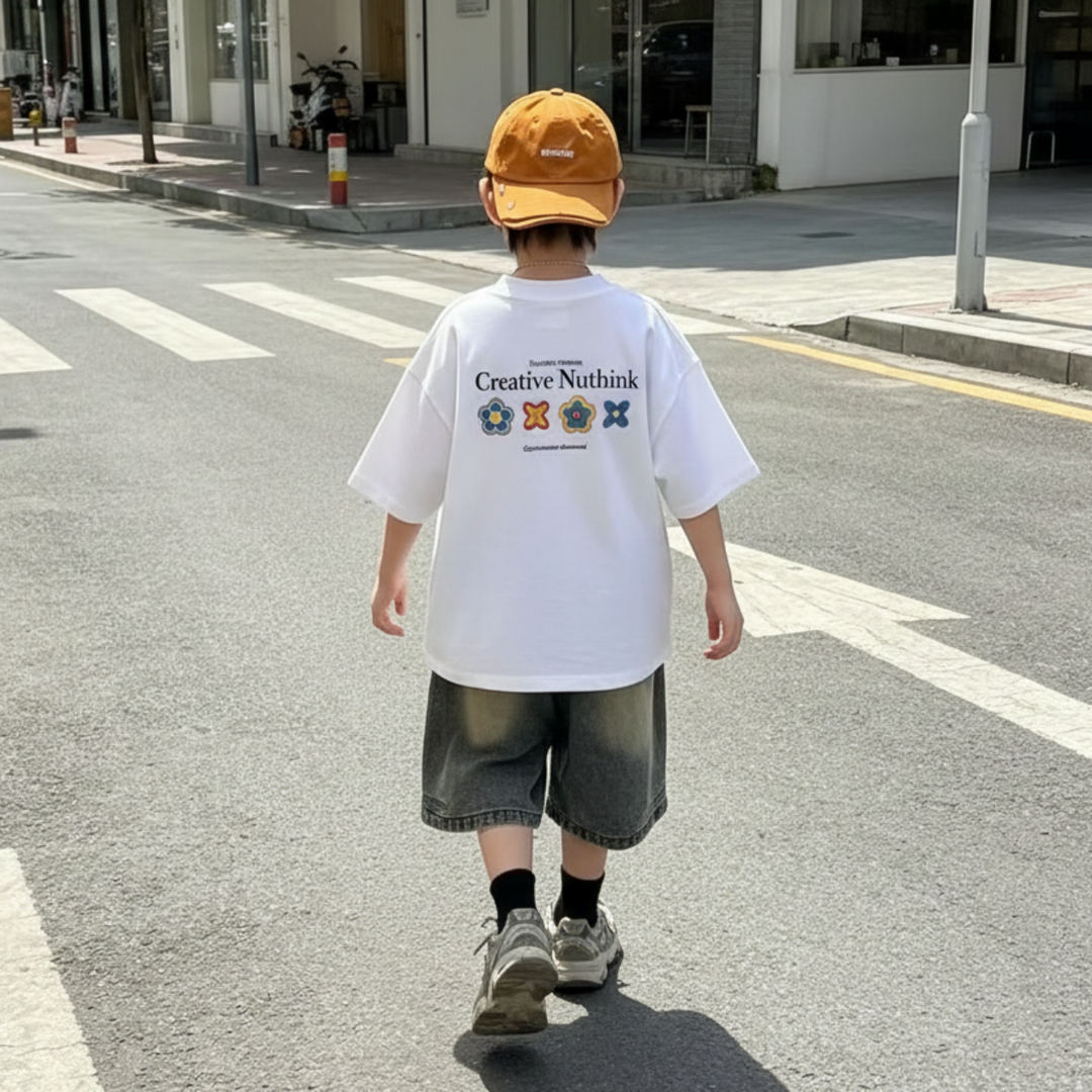 Back view of a white graphic T-shirt worn with denim shorts and a yellow cap