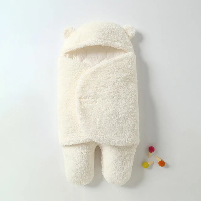 White baby wrap blanket with a textured outer layer, bear-ear hood, and wrapped front.
