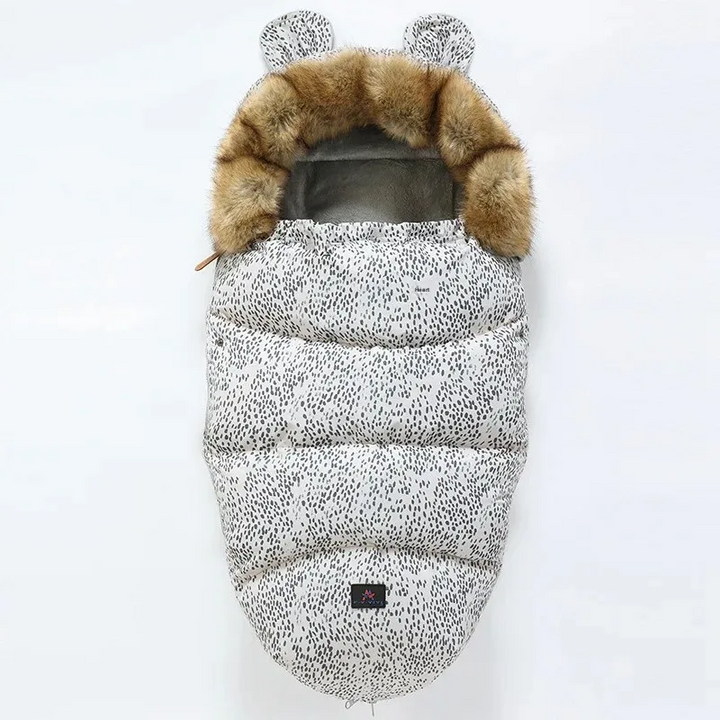 White stroller footmuff with fine black speckles and a faux fur collar