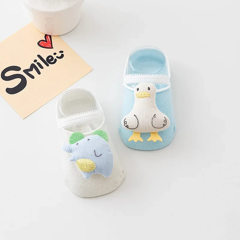 White and blue baby socks with raised elephant and duck decorations