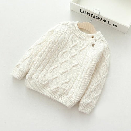 White cable-knit sweater with a round neckline and two shoulder buttons.