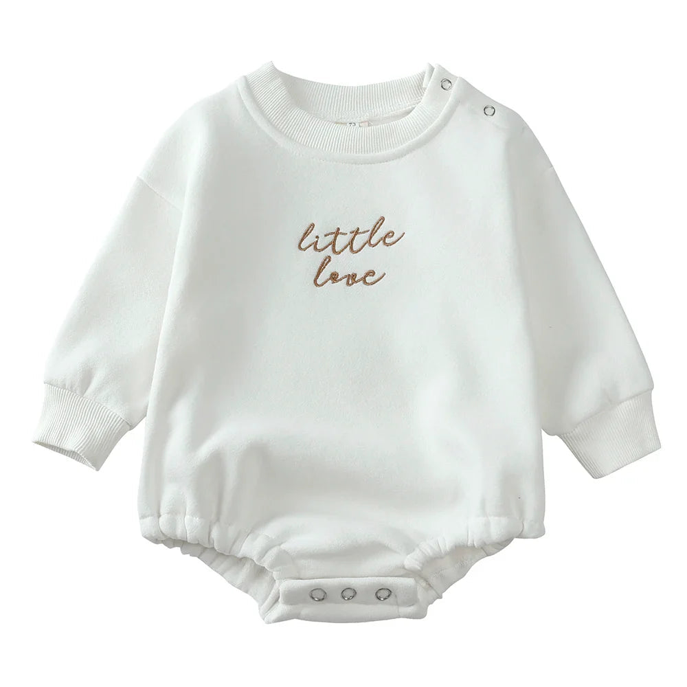 White long-sleeve baby romper with ribbed cuffs, gathered leg openings, and crotch snaps