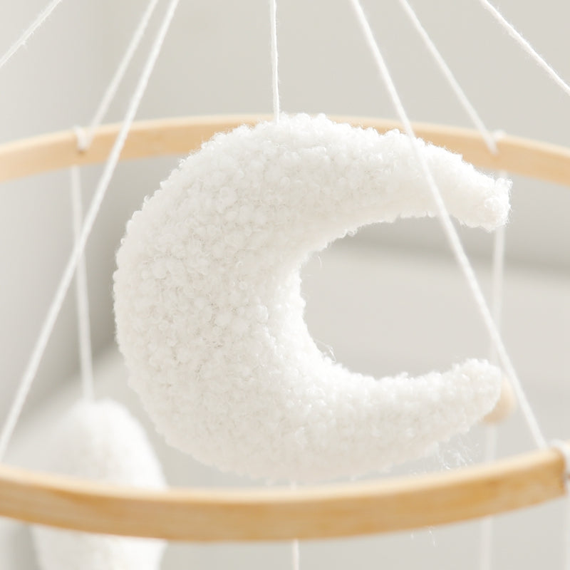 White plush crescent moon hanging inside the baby mobile&