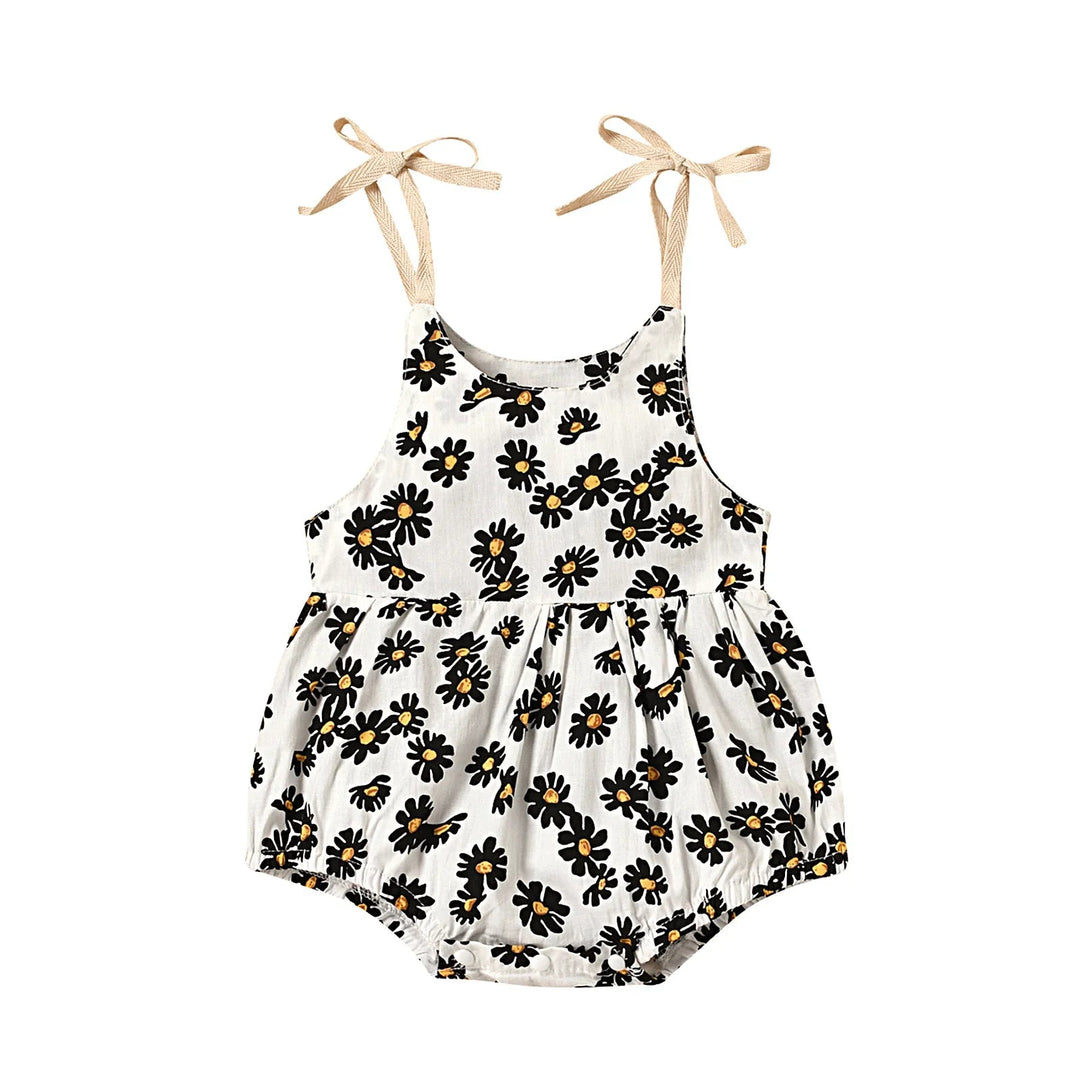 White floral baby romper with dark flower petals and beige shoulder bows