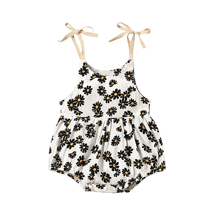 White floral baby romper with dark flower petals and beige shoulder bows