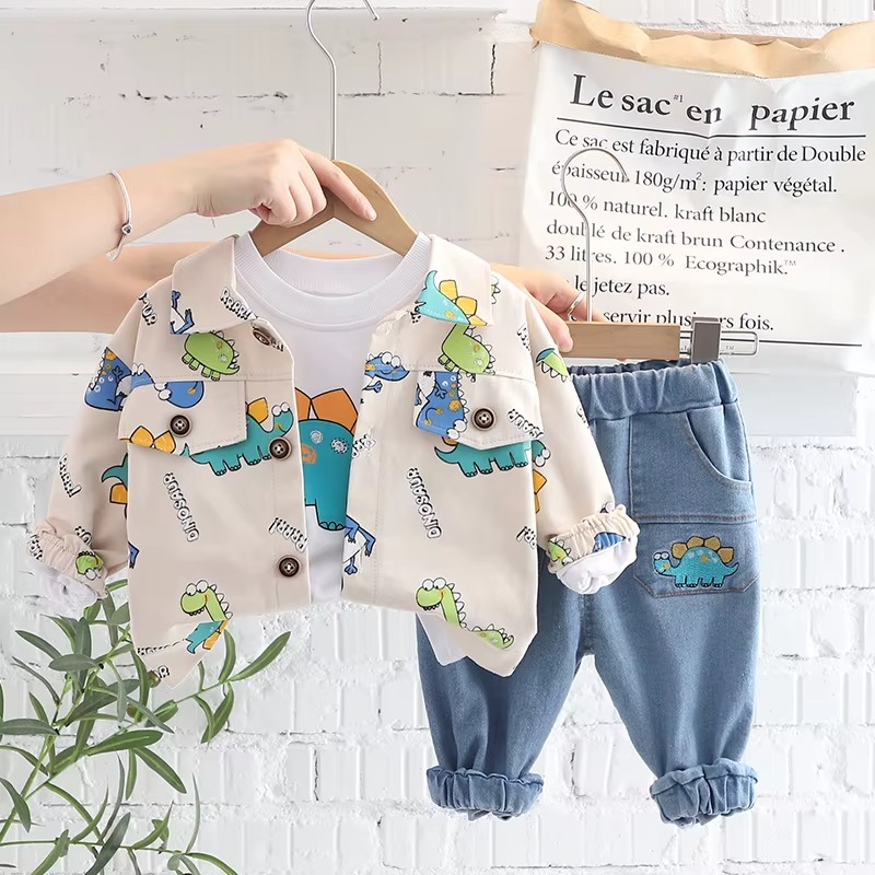 White dinosaur-print jacket, white graphic T-shirt, and blue pants displayed on hangers