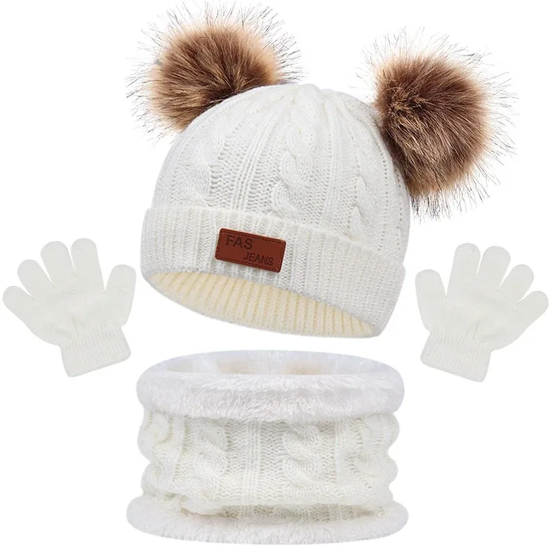 White cable-knit winter set with a double-pom-pom hat, loop scarf, and gloves