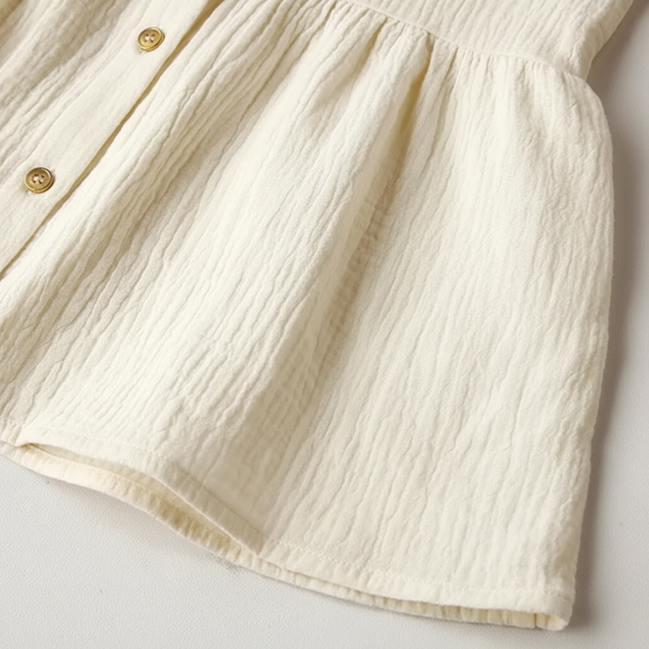 Gathered skirt, front buttons, and hem of the White cotton dress.