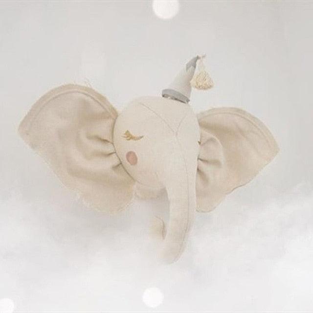 White elephant plush wall accent with wide ears, pink cheeks, and a small tasseled hat