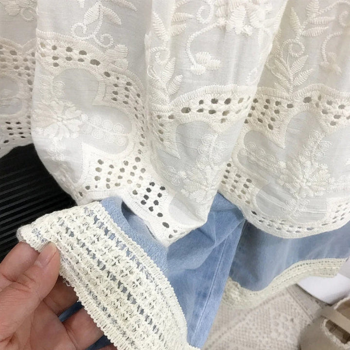 White embroidered top hem beside blue pants with cream lace trim