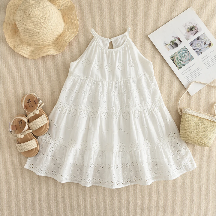 White eyelet dress front view styled with a hat, sandals and a small bag