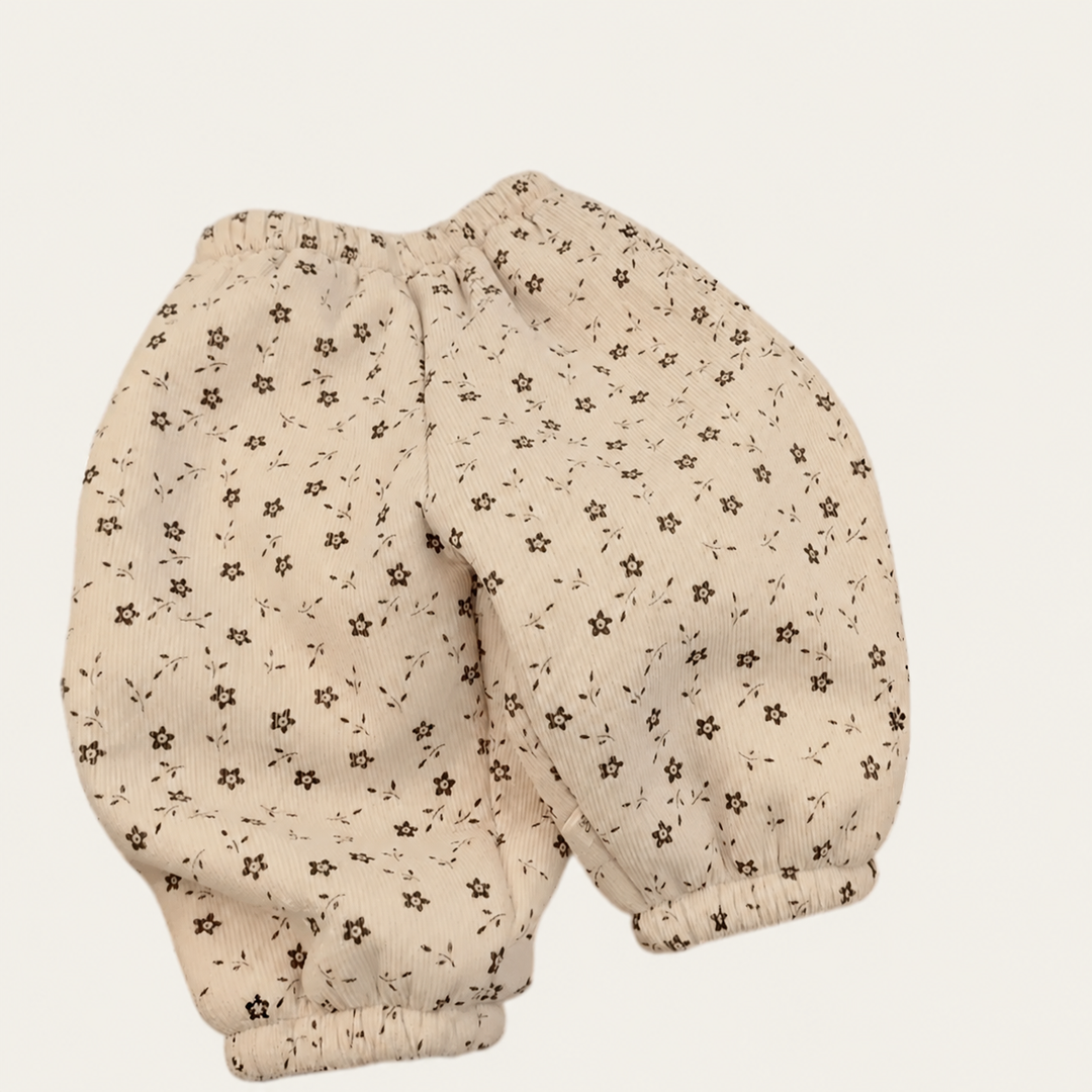White floral corduroy-look pants with an elastic waist and ankle cuffs