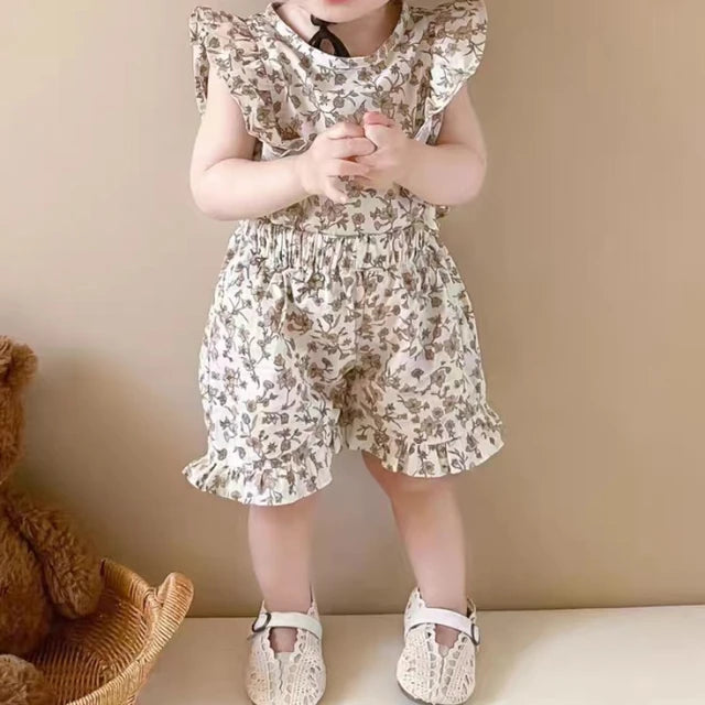 Child modeling the white floral ruffle-sleeve top and matching shorts