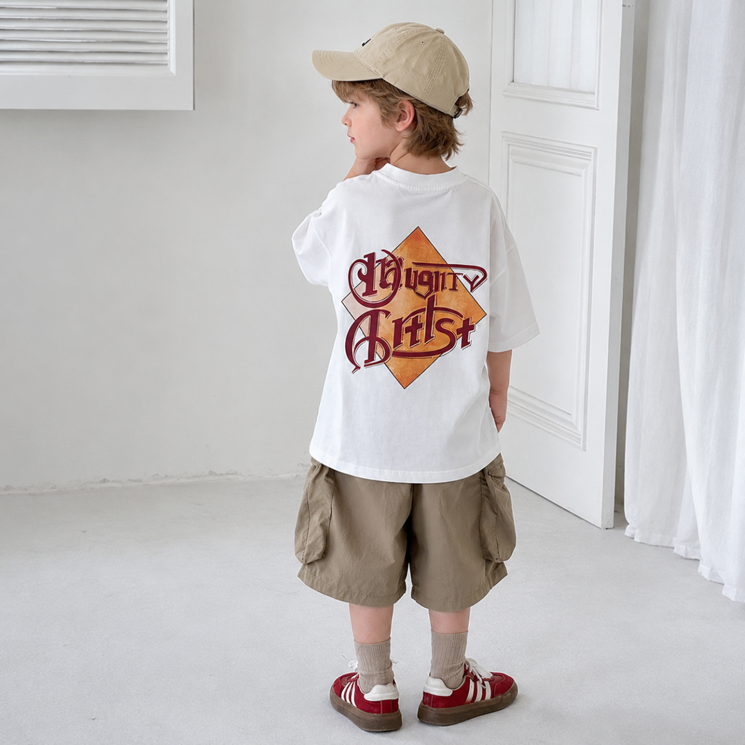 Back view of a child wearing the white graphic T-shirt with khaki shorts