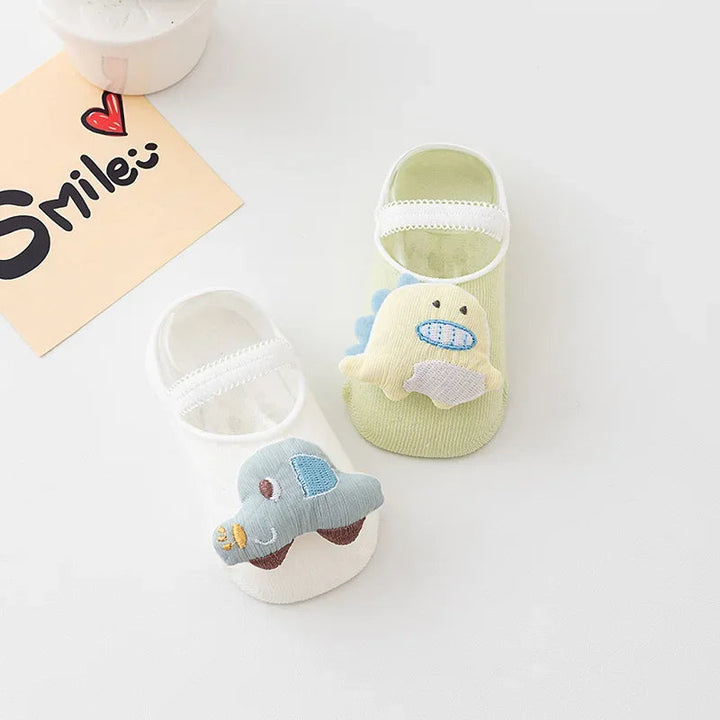 White and green baby socks with raised elephant and smiling character decorations