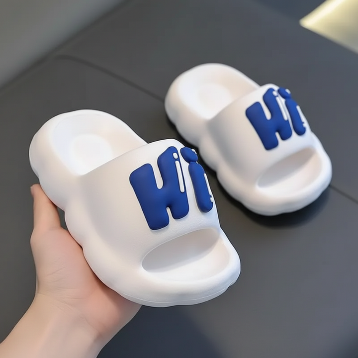White slide slippers with raised blue Hi lettering.