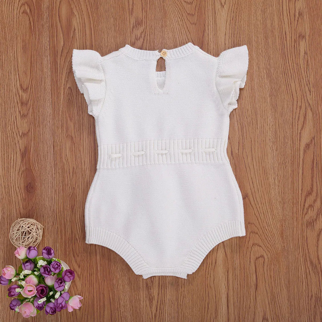White knit baby romper with ruffled sleeves and a textured waistband