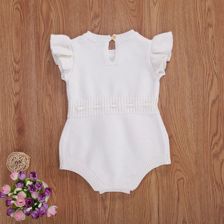 White knit baby romper with ruffled sleeves and a textured waistband