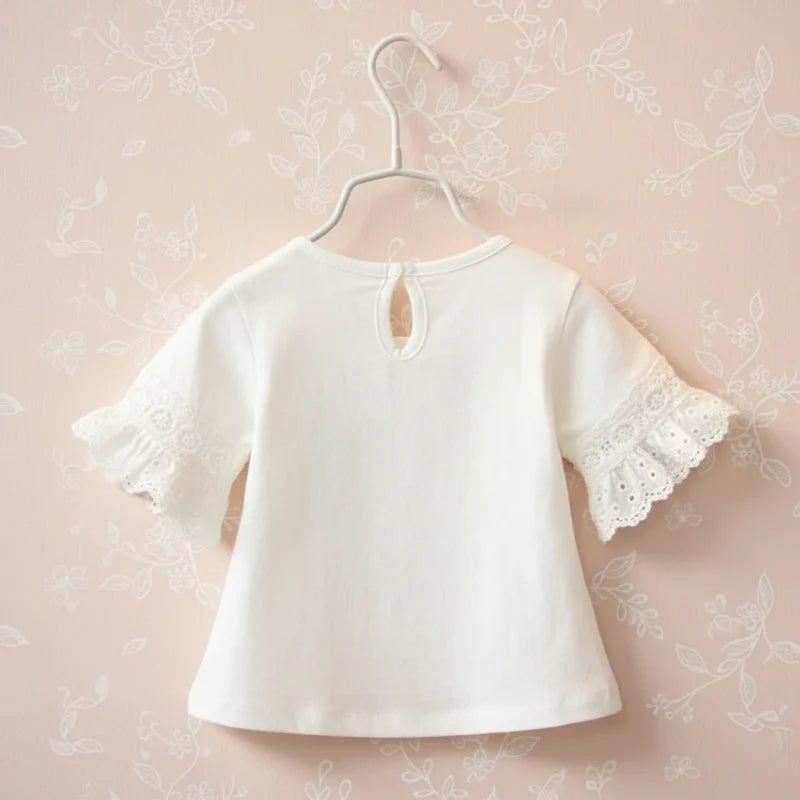 Back view of the white top with a keyhole opening and lace-trimmed sleeves