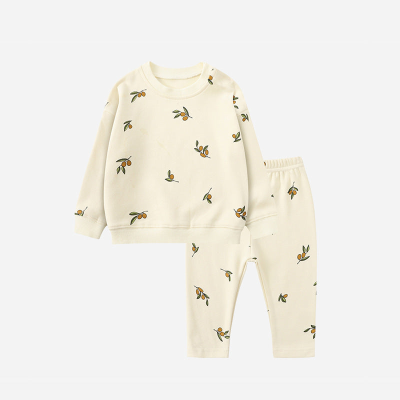 White pajama set with small leafy motifs, a long-sleeve sweater, and matching pants.