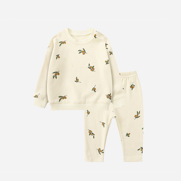 White pajama set with small leafy motifs, a long-sleeve sweater, and matching pants.