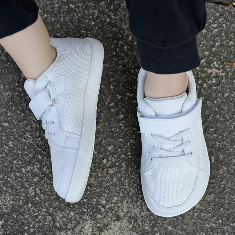 White mesh sneakers viewed from above while worn with black pants