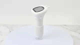 White portable microscope standing upright on a tabletop.