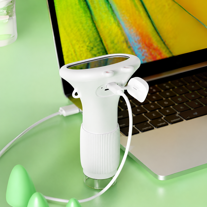 White microscope connected by USB to a laptop showing a magnified view.