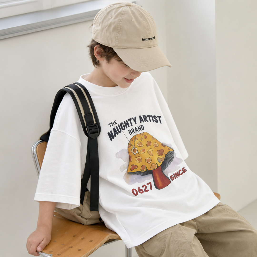 Child wearing a white mushroom graphic T-shirt with a backpack and khaki shorts