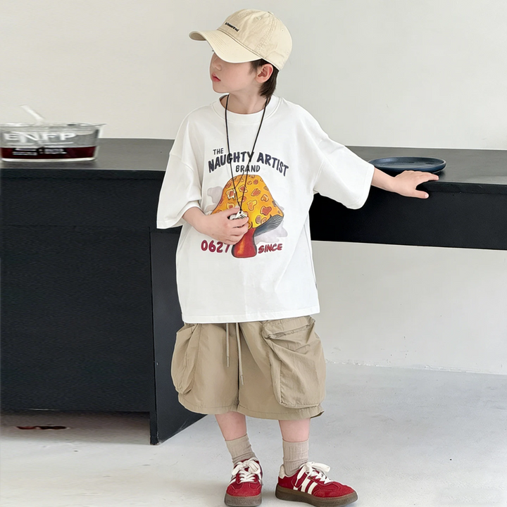 Child modeling the white oversized mushroom T-shirt with shorts and red sneakers