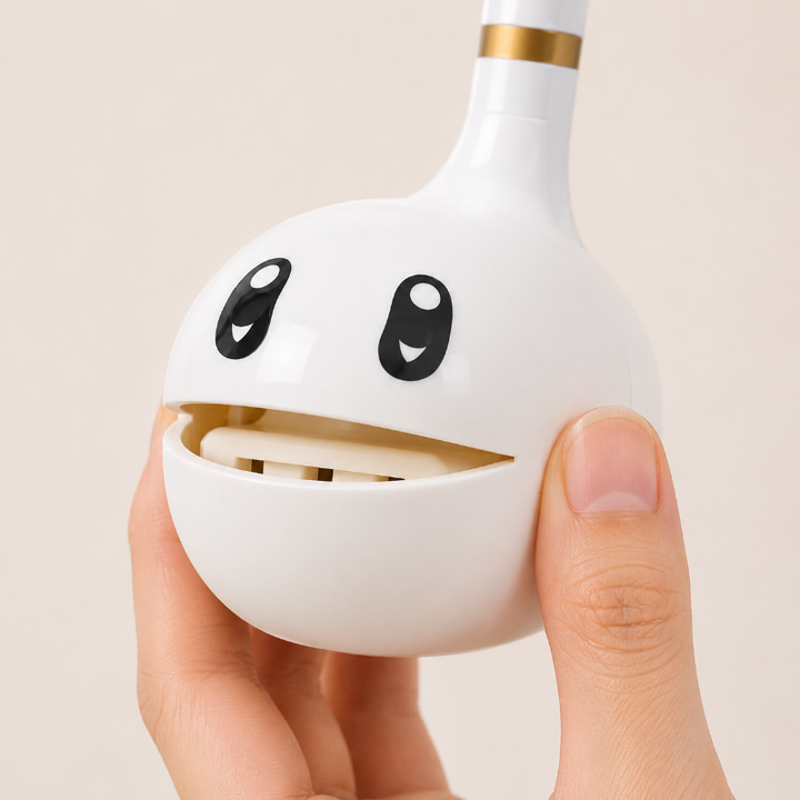 Close-up of a hand holding the white music toy with its round mouth open.
