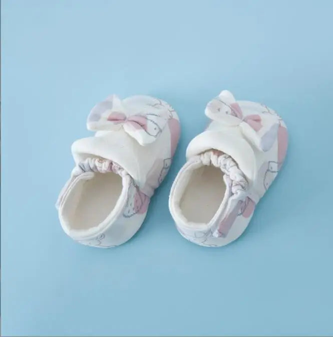 White and pink baby shoes with bows and gathered openings