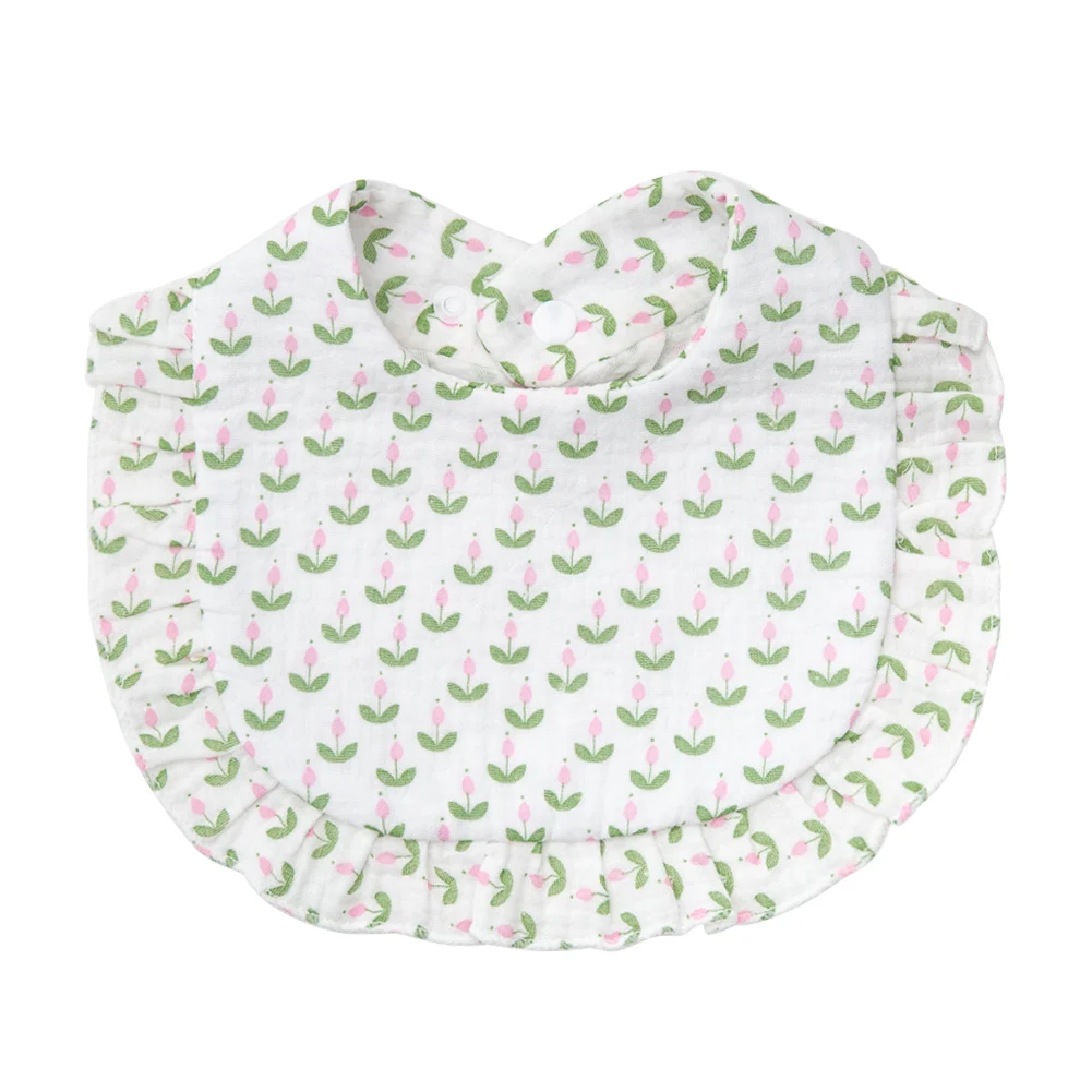 White cotton baby bib with pink tulips, green leaves, and a ruffled border