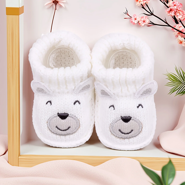White polar bear baby booties with gray face details and folded cuffs
