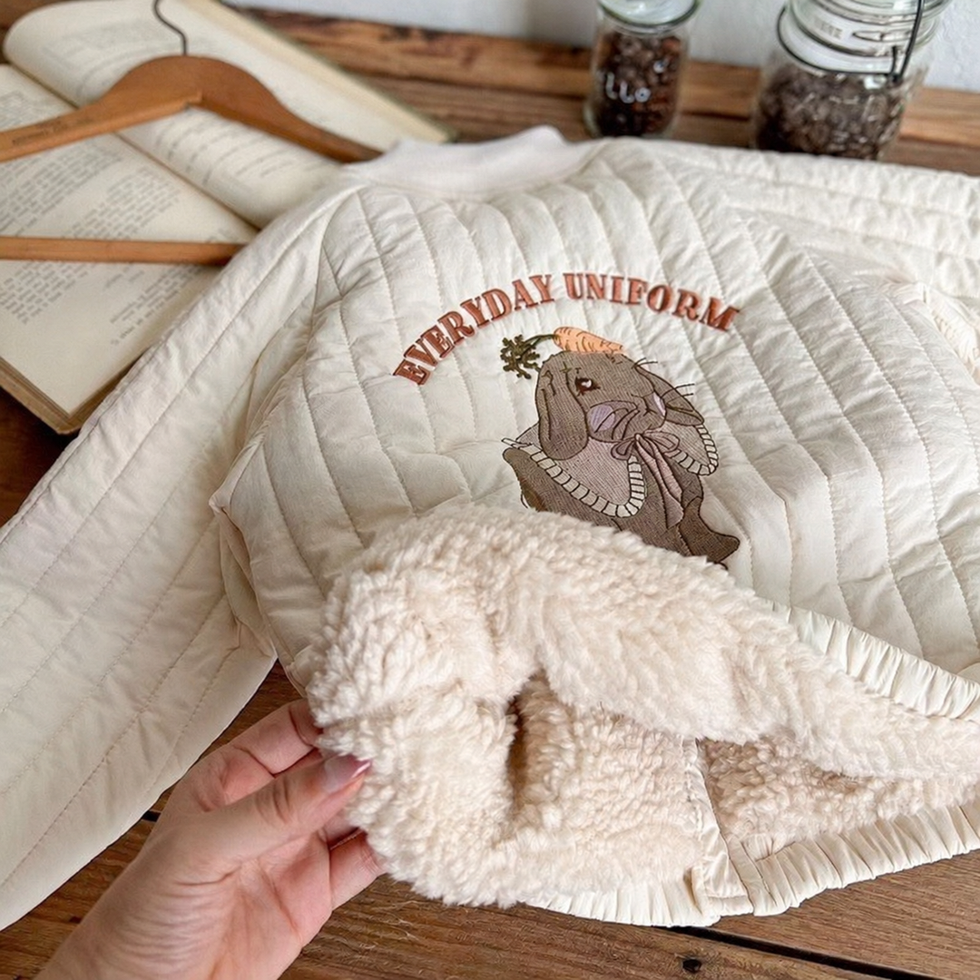 White quilted jacket with animal embroidery and plush-textured lining turned outward