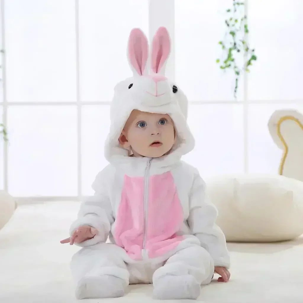 Baby wearing a white rabbit onesie with tall pink-lined ears and a pink belly