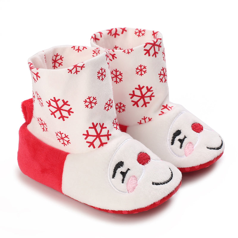 White and red baby booties with snowflake cuffs and smiling faces