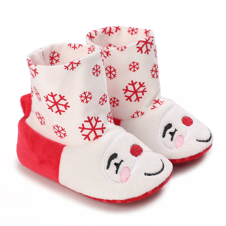 White and red baby booties with snowflake cuffs and smiling faces