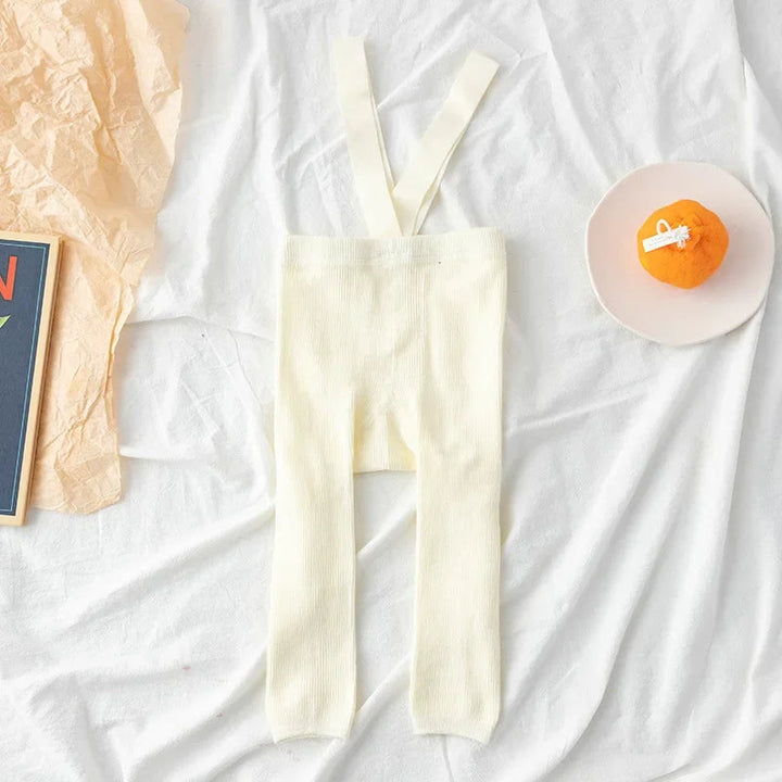 White ribbed baby leggings with matching suspenders laid flat