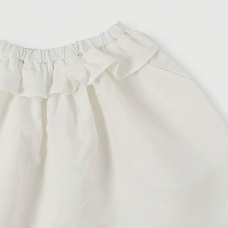 White skirt detail showing the gathered elastic waist and soft ruffle