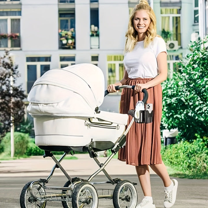 Woman standing beside a white stroller with a cup and phone holder attached.